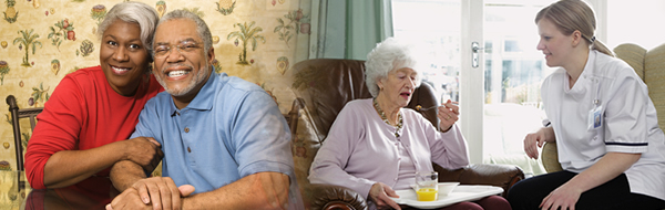 Couple smiling - Caregiver assisting the old woman in her meal